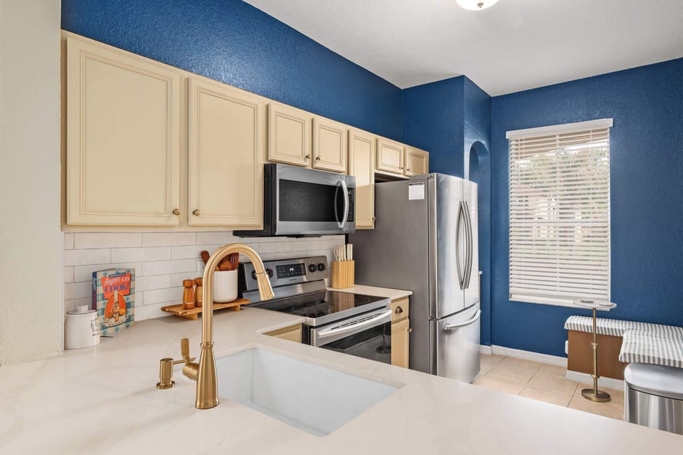Bright kitchen w/ blue accents, stainless appliances & plenty of counter space