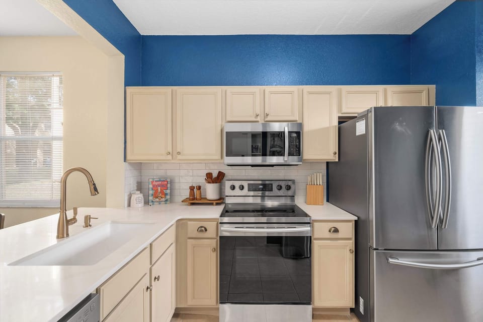 Modern kitchen w/ blue accents, stainless appliances & plenty of prep space