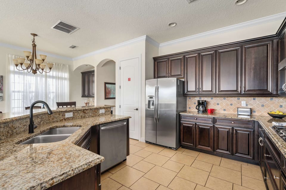 Modern kitchen w/ dark cabinets, stainless appliances & ample counter space