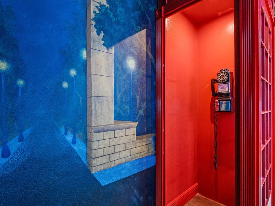Quirky red phone booth entrance adding a playful themed touch to the space