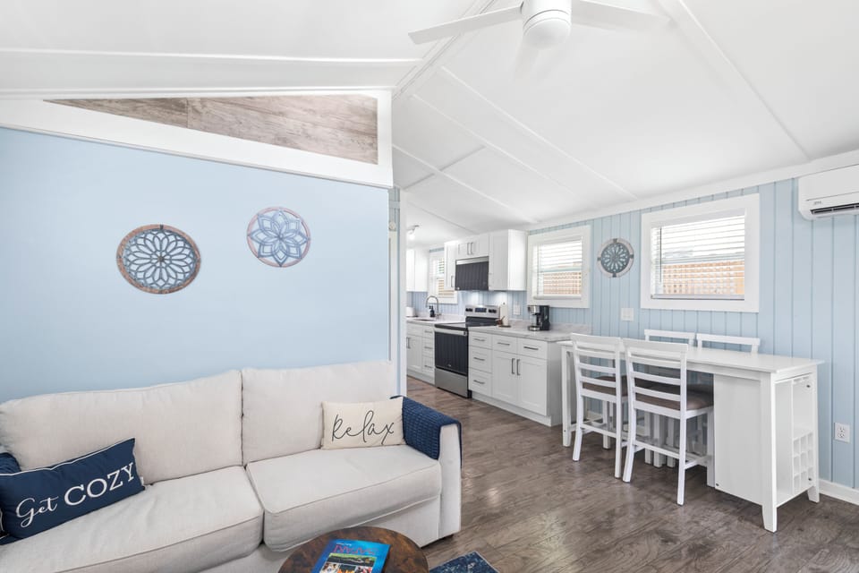 Open-concept living and dining area with modern white cabinetry and bright interiors.