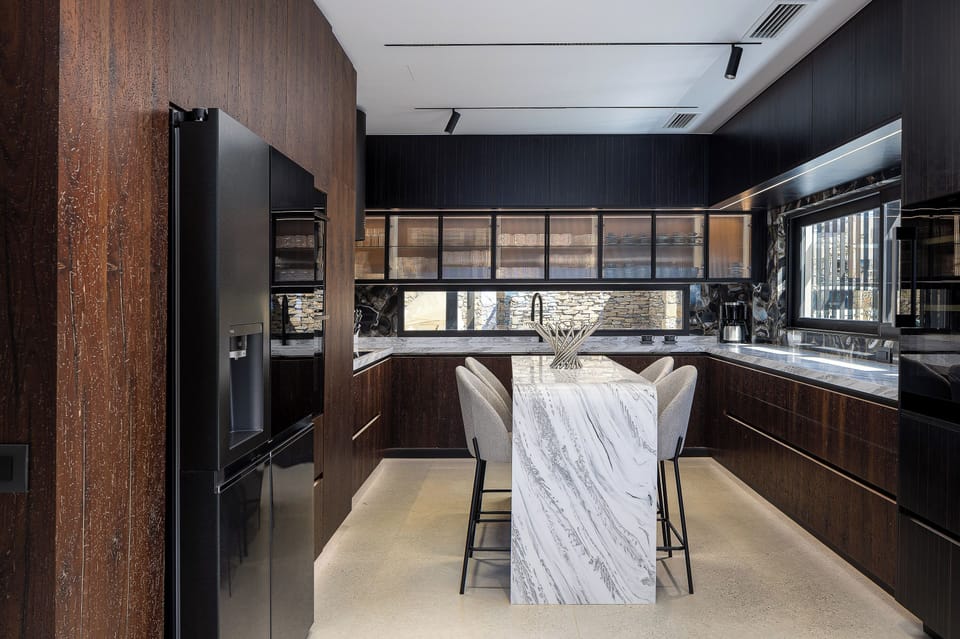 Fully equipped kitchen finished in VENETIAN wood, CORIAN counter, featuring modern appliances and a wine fridge