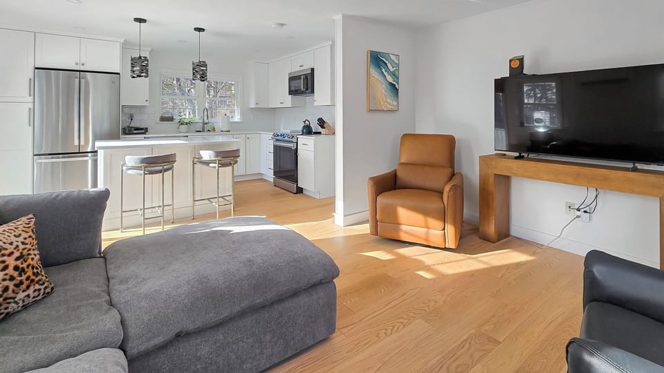 Living room has comfortable seating and a large flat screen TV