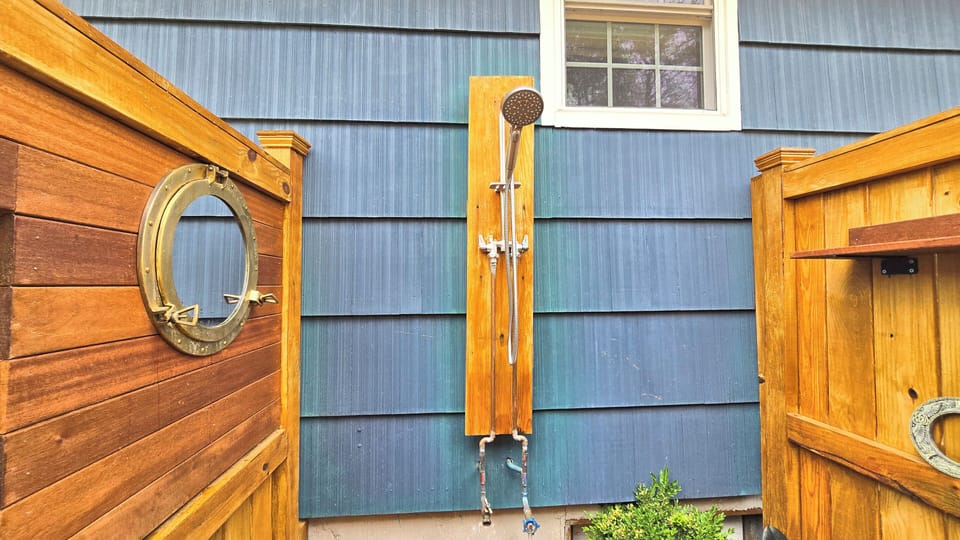Oversized enclosed outdoor shower at the back of the house