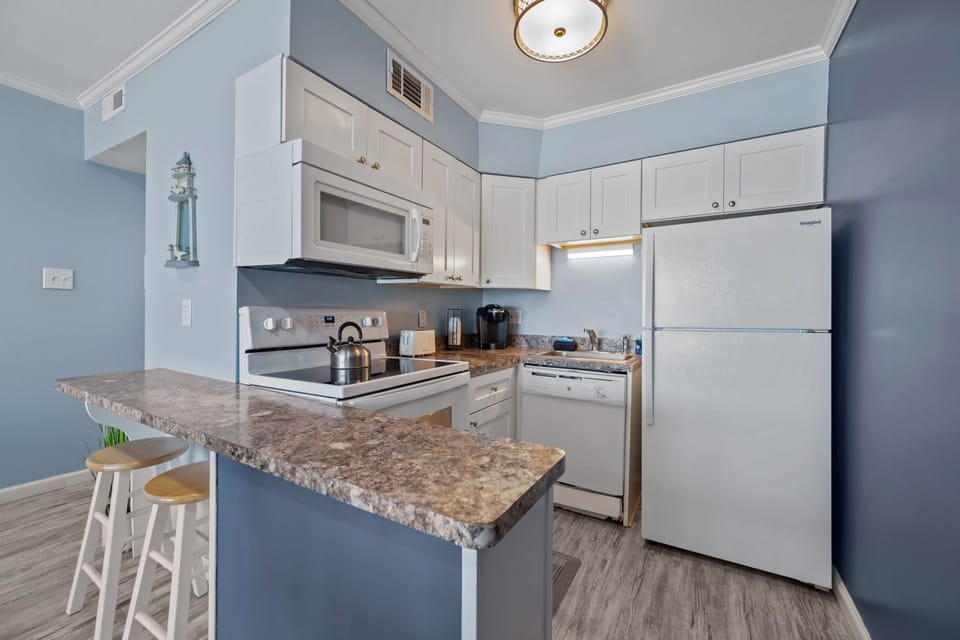 Fully stocked kitchen with breakfast bar for easy mornings before the beach

