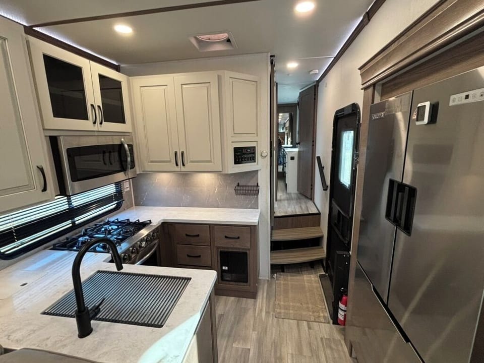 Kitchen with a residential size fridge, four burner stove top and oven