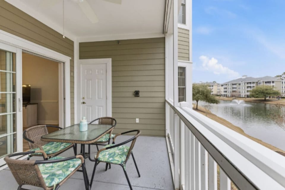 Relax and unwind on your private screened-in balcony overlooking the peaceful lake and fountain views. This inviting outdoor space features comfortable seating, perfect for morning coffee, outdoor meals, or evening drinks in the fresh coastal air. With se