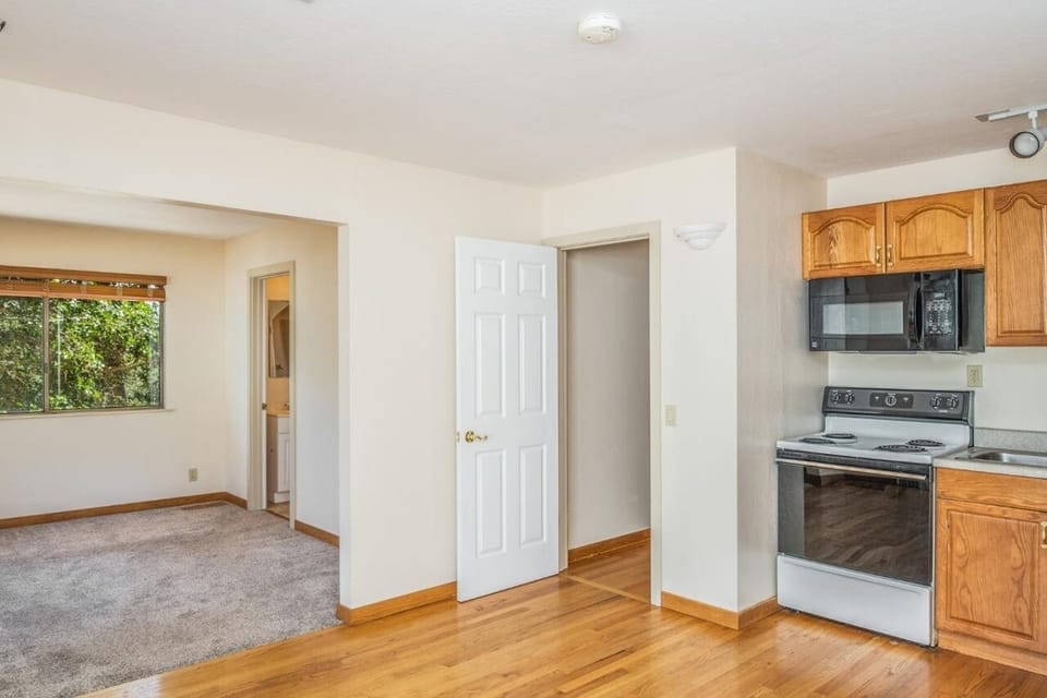 Kitchen before furniture. Carpeted living room to left before furnished.