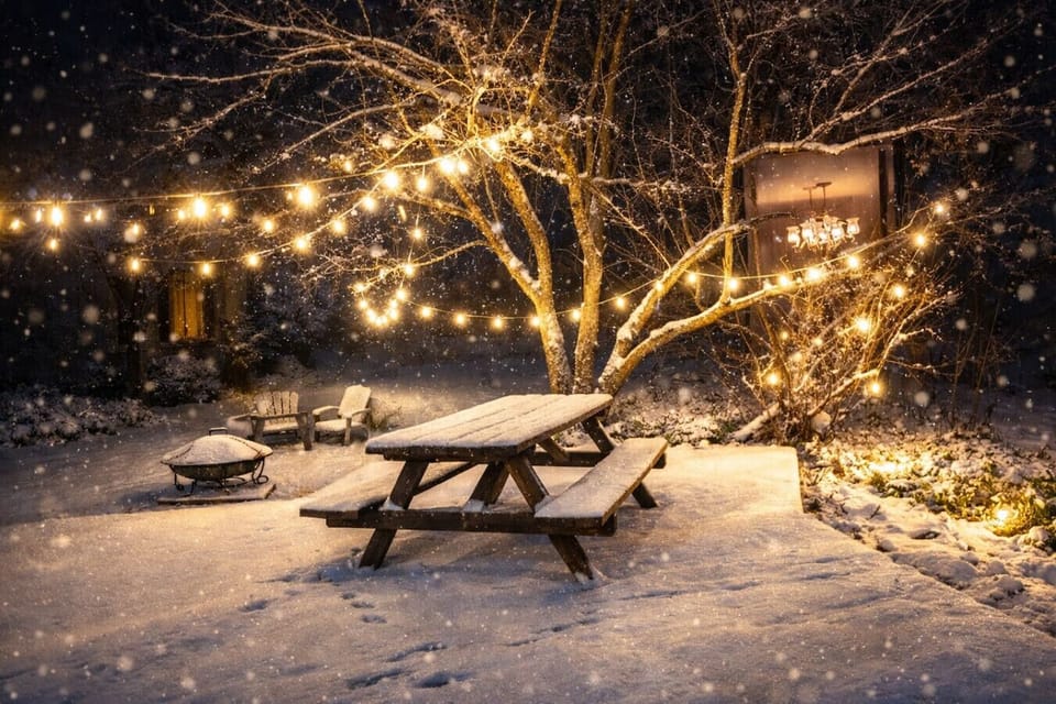 Step outside to a spacious wooden deck and lush lawn, featuring a charming picnic area and fire pit perfect for starlit gatherings. Strung Edison lights and comfortable seating create an enchanting evening glow, offering a private backyard oasis for dinin