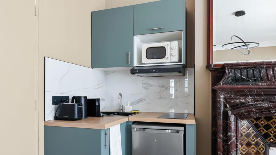 Un espace optimisé aux teintes douces, parfaitement équipé pour préparer vos repas.