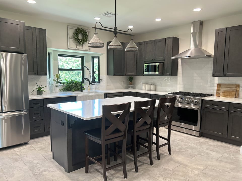 Kitchen includes large refrigerator, large gas stove, and dishwasher.
