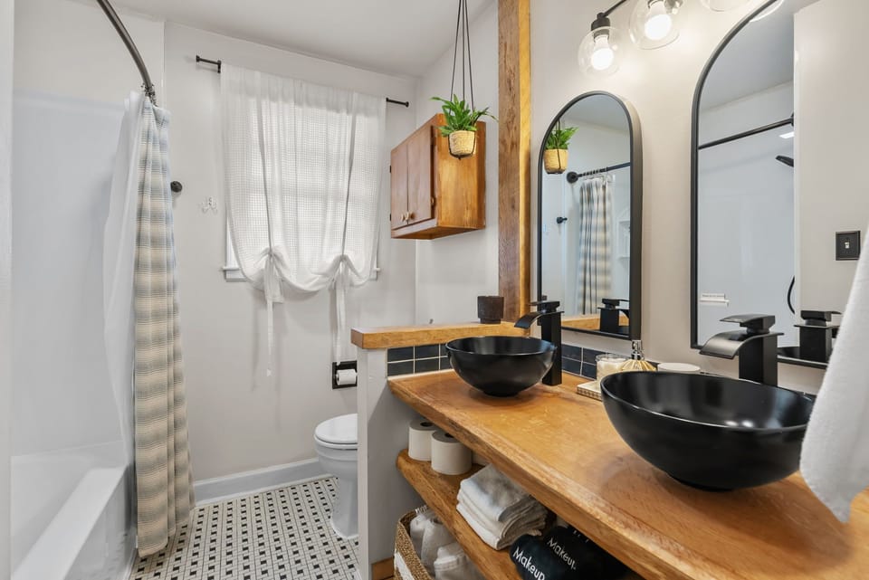 Hallway bathroom with shower and his & hers sinks.