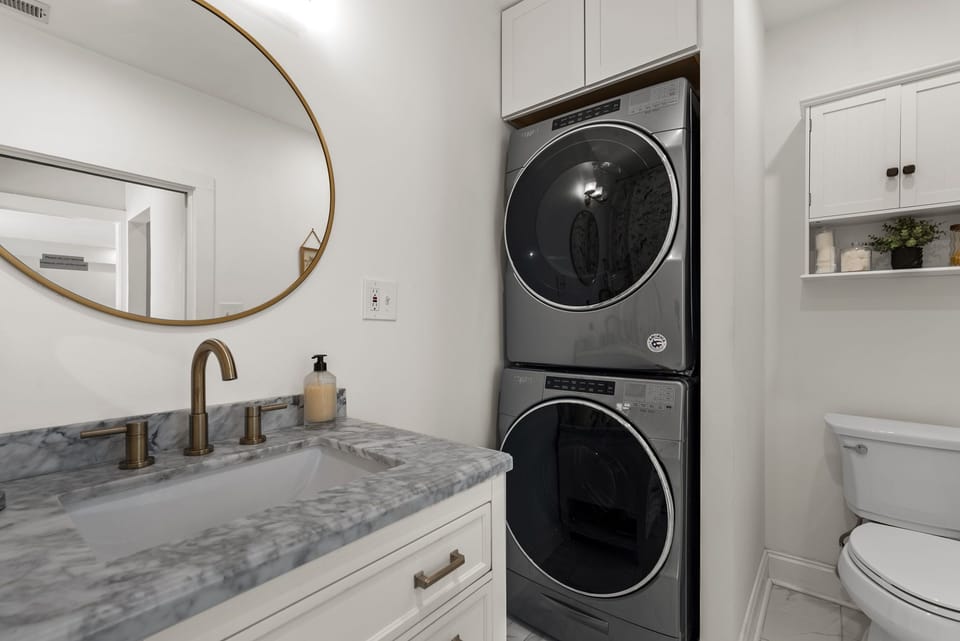 Bathroom attached to primary bedroom with shower/tub combo and washer dryer.