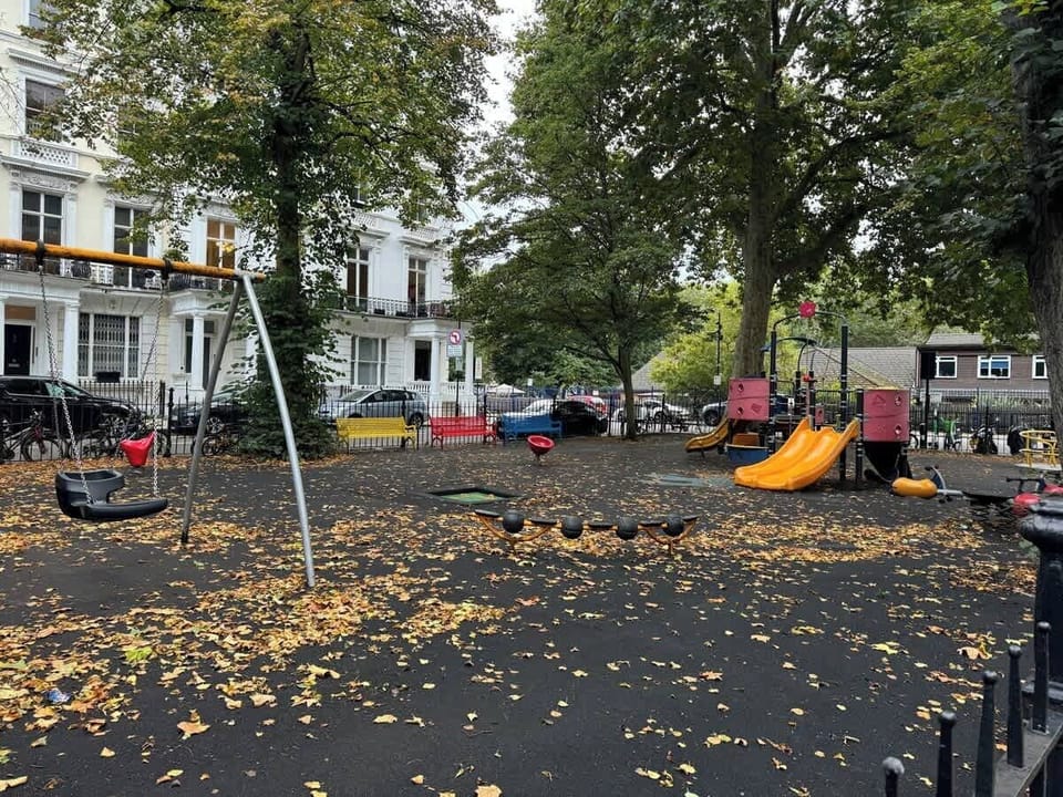Bring the kids to enjoy this neighborhood playground, complete with bright yellow slides, swing sets, and play structures surrounded by mature trees and classic white townhouses.
