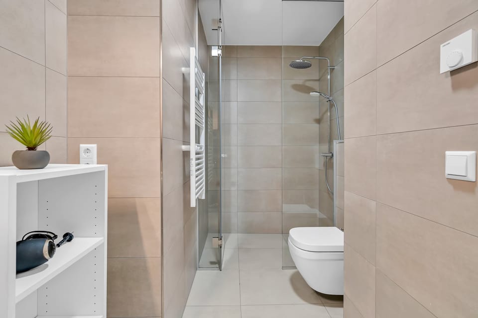 Bathroom with glass shower, clean finishes, and all essential amenities.