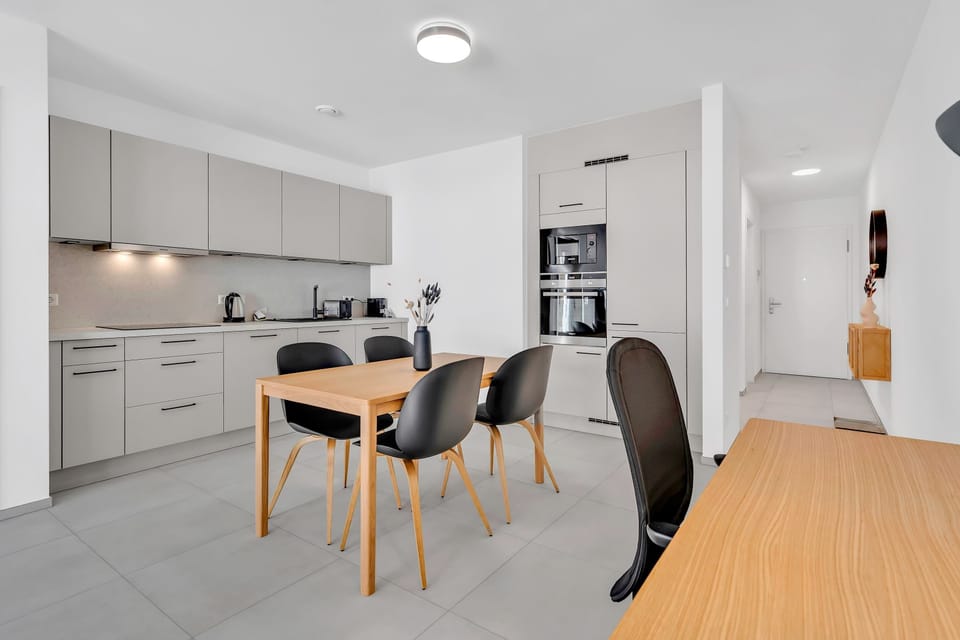 Modern kitchen with dining setup and clean, minimalist finishes.