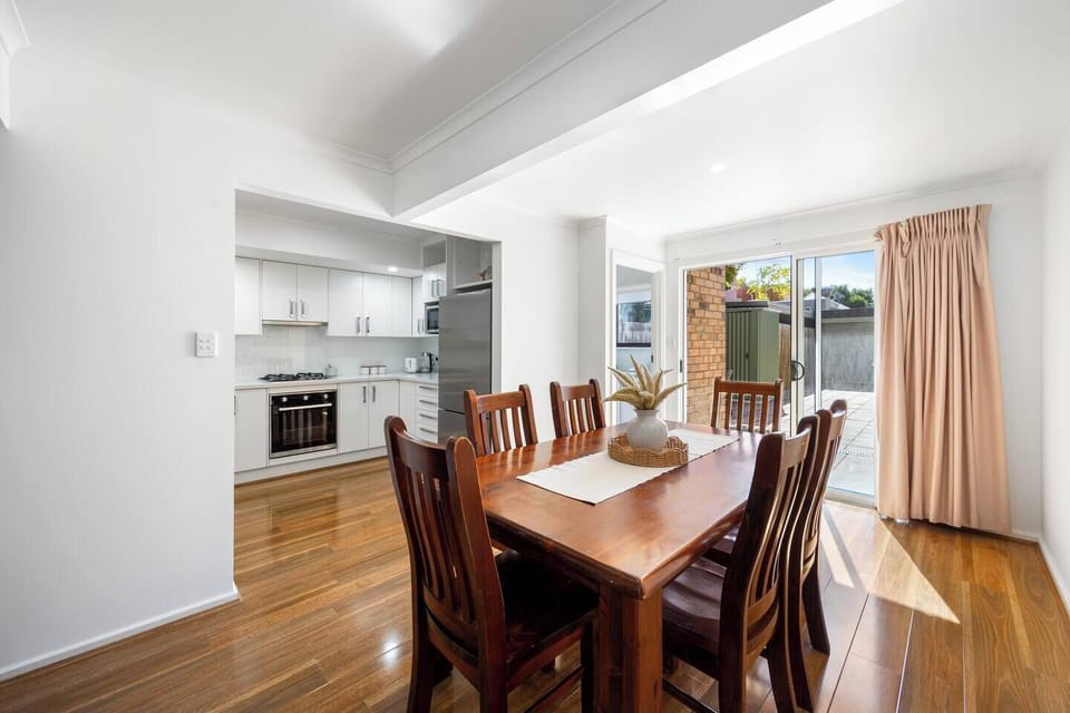 A warm, inviting dining space perfect for shared meals, seamlessly flowing into a sunlit courtyard beyond.