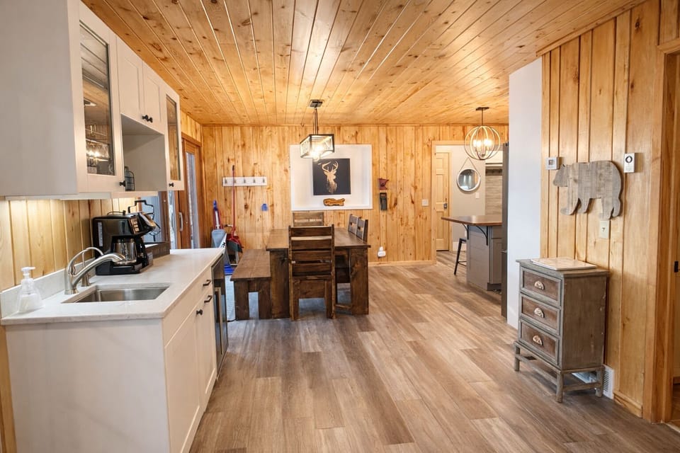 The wet bar, dining area, and kitchen flow together with a cute modern design that feels both stylish and inviting.