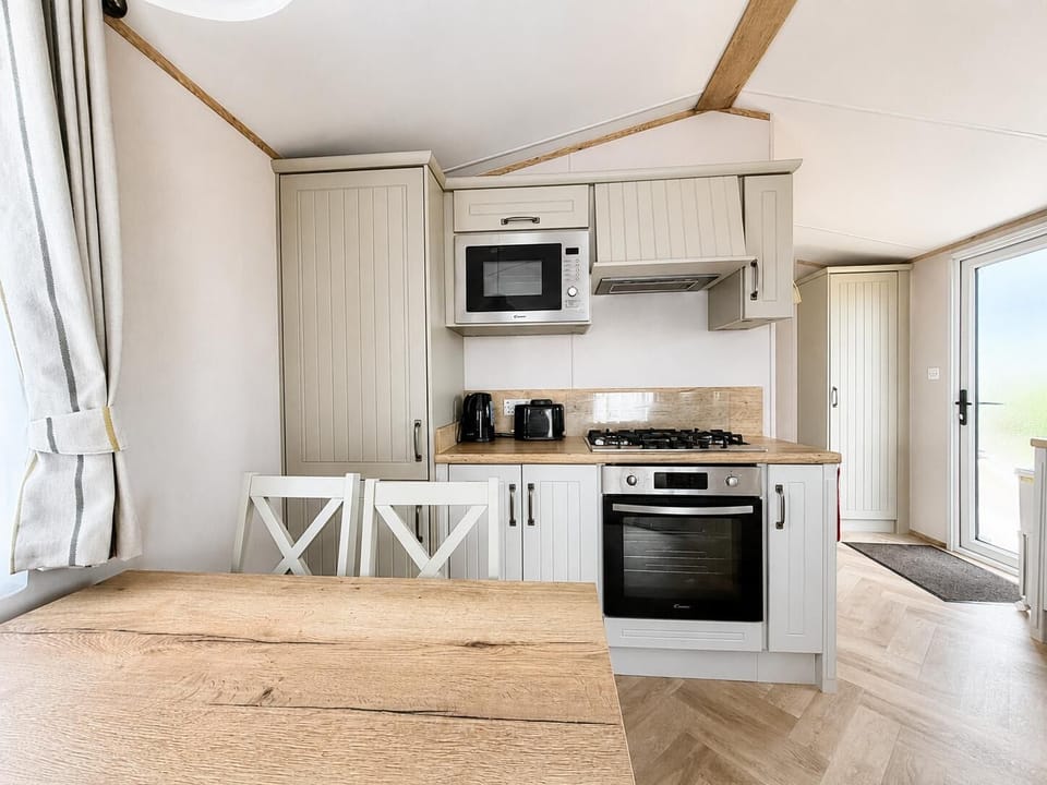 The dining table in this modern coastal caravan seats 4 comfortably. Once dinner is prepared and served you can reach for the cards and board games and enjoy a family games night. Who will win.
