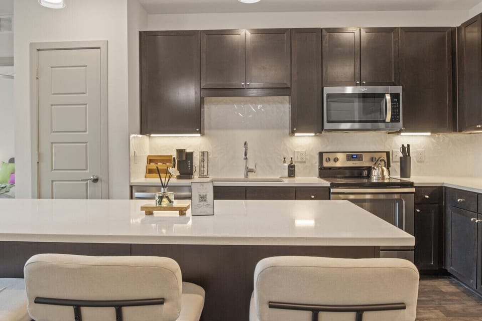 Fully equipped kitchen with island seating, modern appliances and coffee station