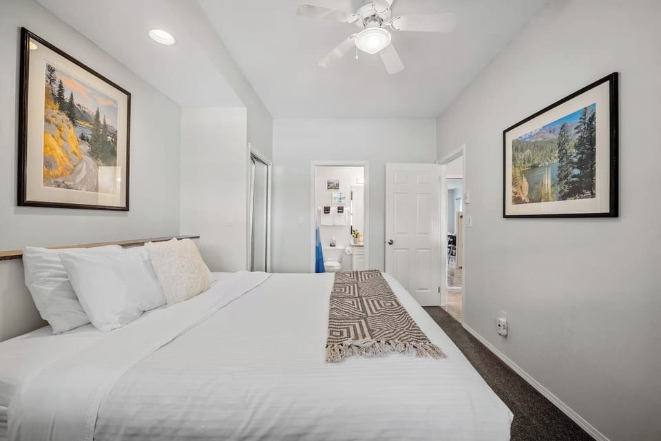 Primary bedroom with a king bed, closets, room-darkening shades, a Smart TV and ensuite access to the bathroom.