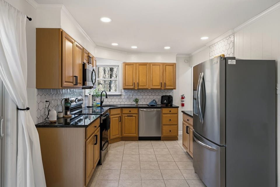 Fully equipped kitchen with stainless steel appliances and ample cabinetry.
