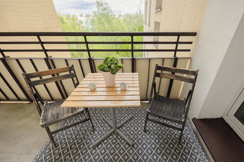 A balcony setup with a small table and chairs. It’s a cozy spot for enjoying coffee or meals outdoors.