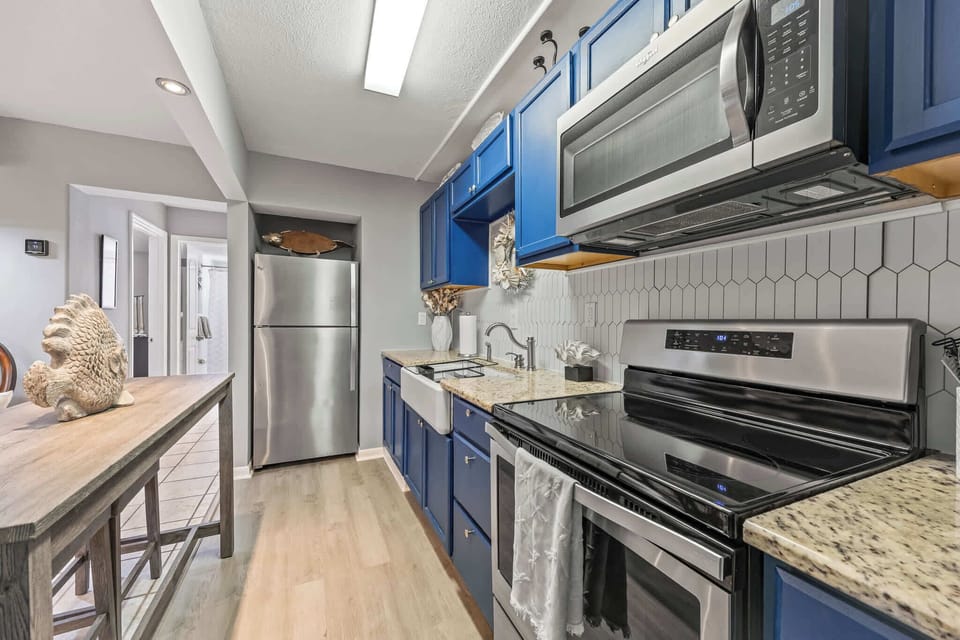 Modern kitchen featuring blue cabinetry and stainless steel appliances.