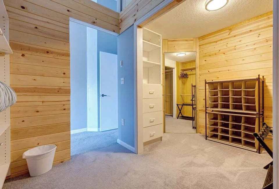 Spacious walk-in closet with wood paneling and ample storage options.