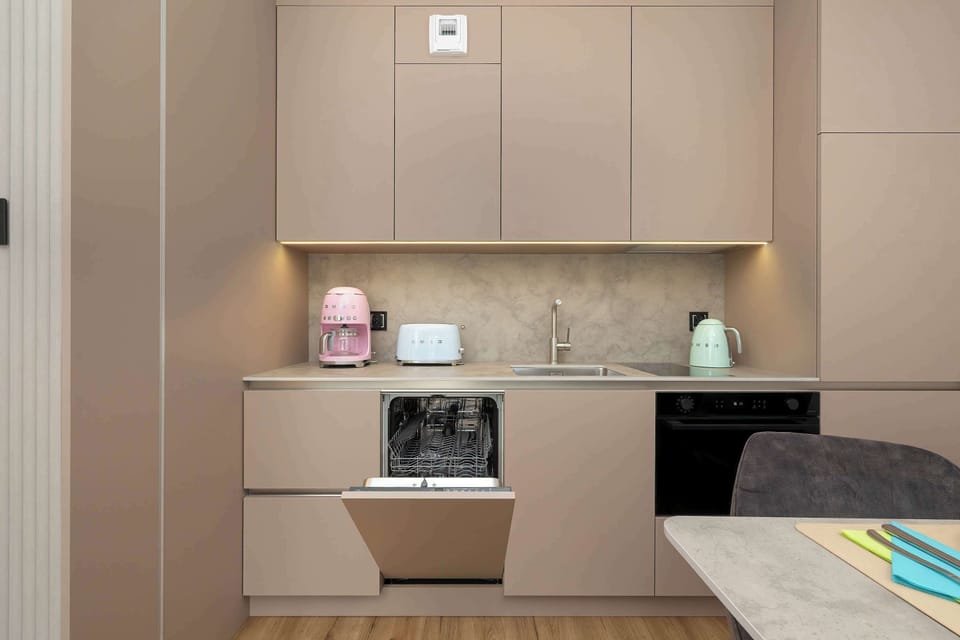 A tidy kitchen area with built-in appliances and subtle lighting under cabinets.