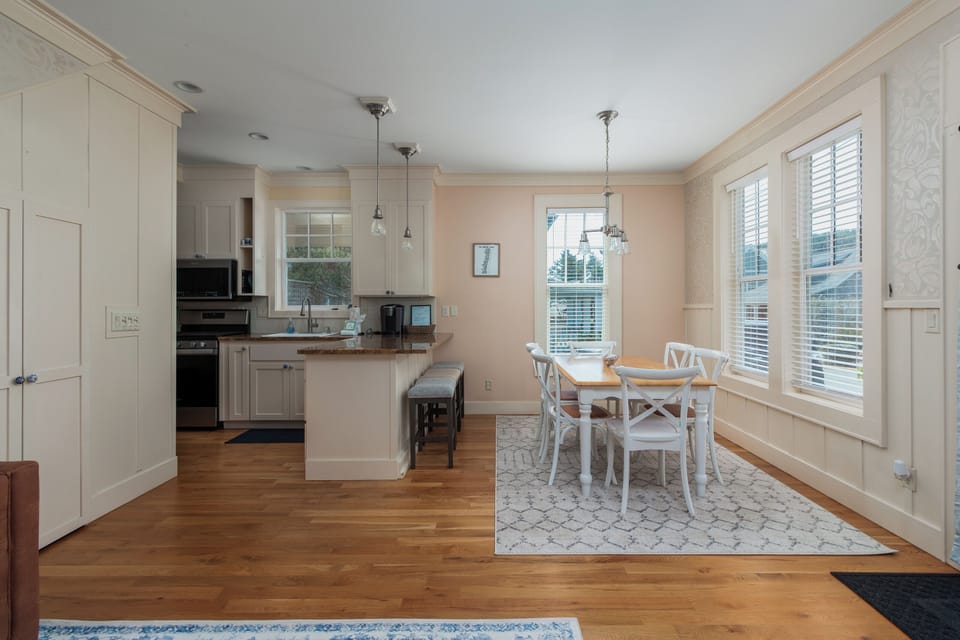 Your bright, open kitchen flows seamlessly into a charming dining nook with warm hardwood floors and natural light streaming through plantation shutters.