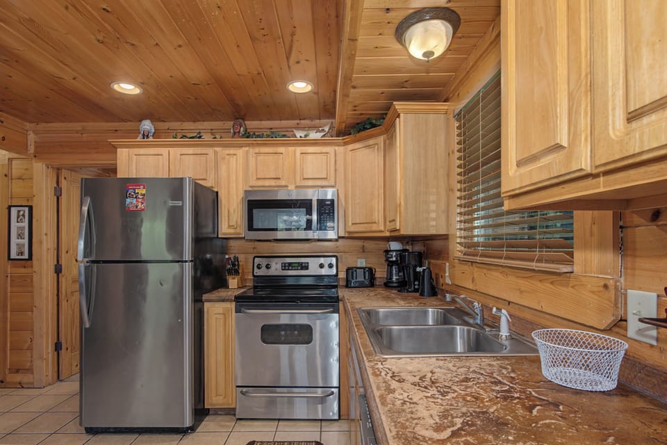 Your fully equipped kitchen features stainless steel appliances and warm wood cabinetry, perfect for preparing family meals during your mountain getaway.