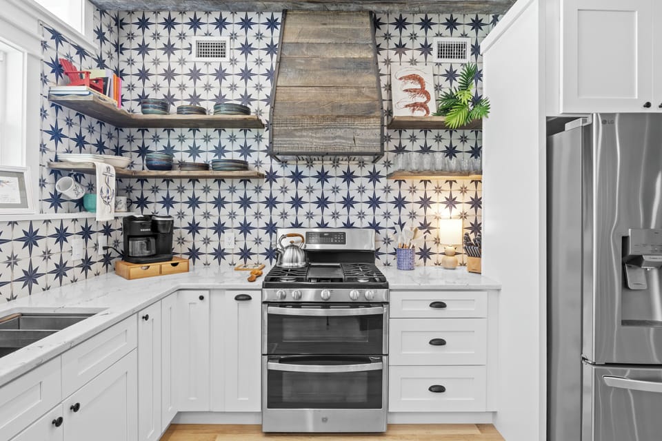 Your fully equipped kitchen blends modern appliances with stunning star-pattern tiles and rustic wood accents for memorable home-cooked meals.