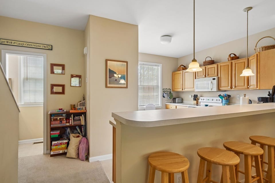 Gather around the breakfast bar for morning coffee or casual meals. Warm wood tones and ample natural light create a welcoming space where your group can connect.