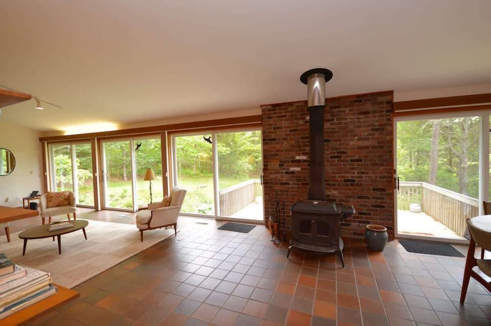 Wood stove and full wall of sliding glass doors that open up to the deck