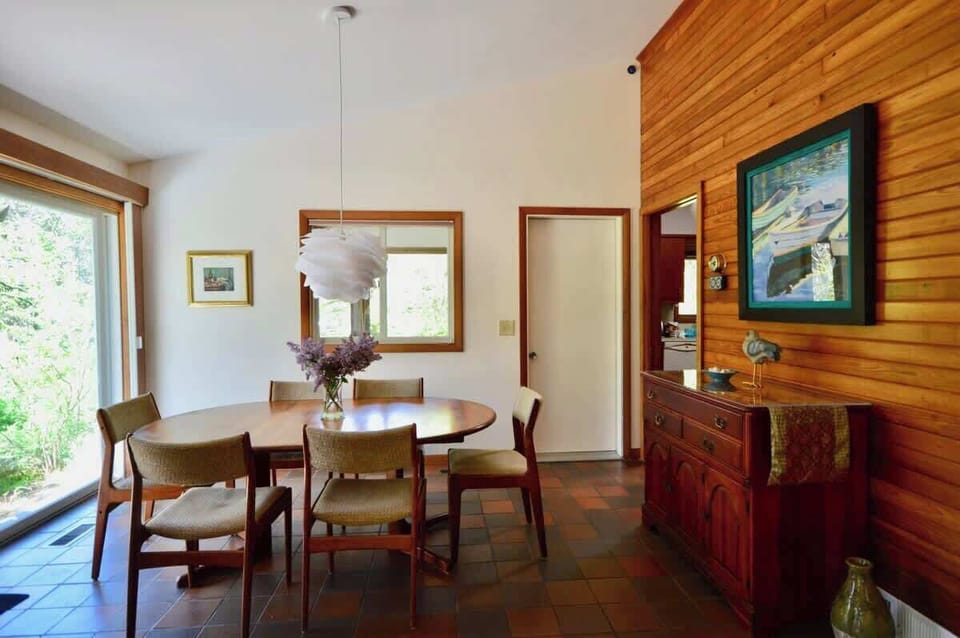 Dining table opens onto deck. Screened porch and kitchen adjacent