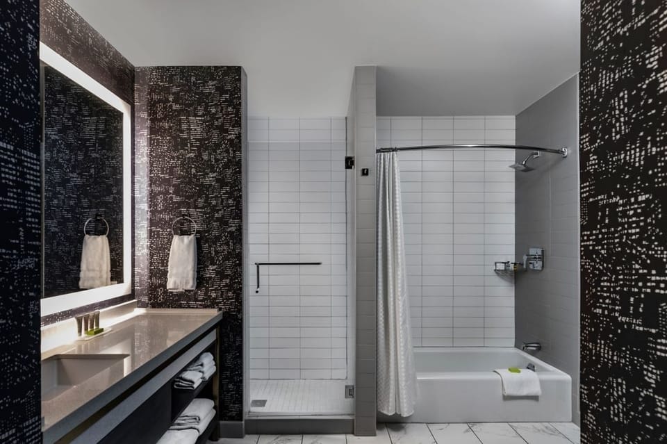 Refresh in a sleek, spacious bath with bright vanity lighting
