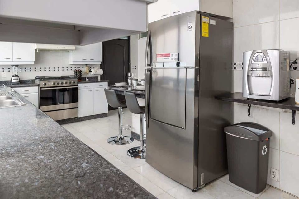 Modern kitchen with full-size refrigerator and all the essentials for cooking at home.