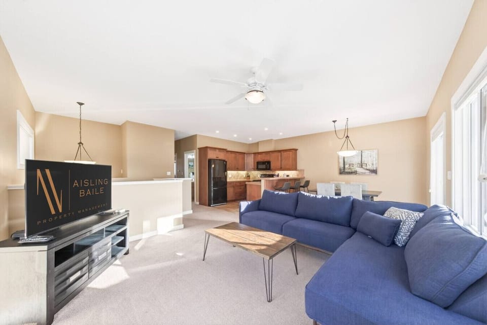 Main living room, located upstairs, with a Smart TV, a cozy couch, and walkout access to the balcony.