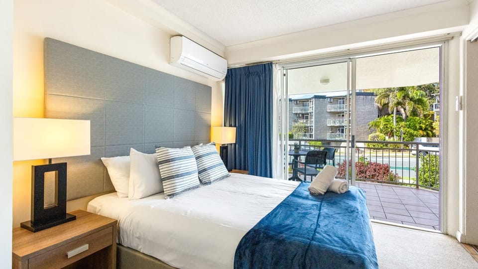 Double bed with balcony access for comfortable sleep and split air conditioner 