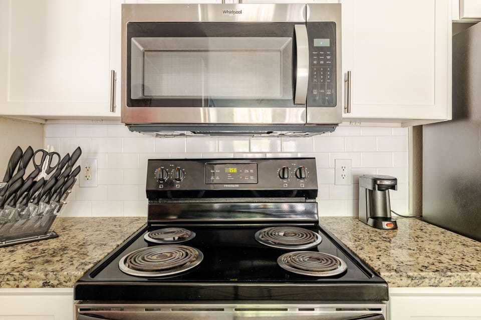 Modern kitchen with granite counters, coffee maker, and full-size stove
