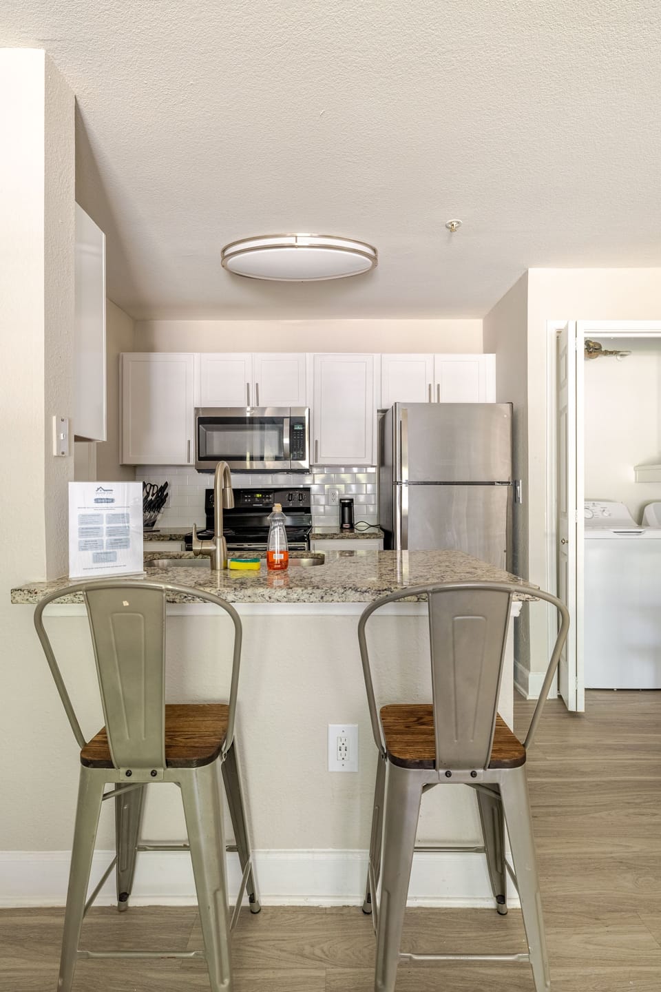 Bright modern kitchen with breakfast bar, stainless appliances & laundry