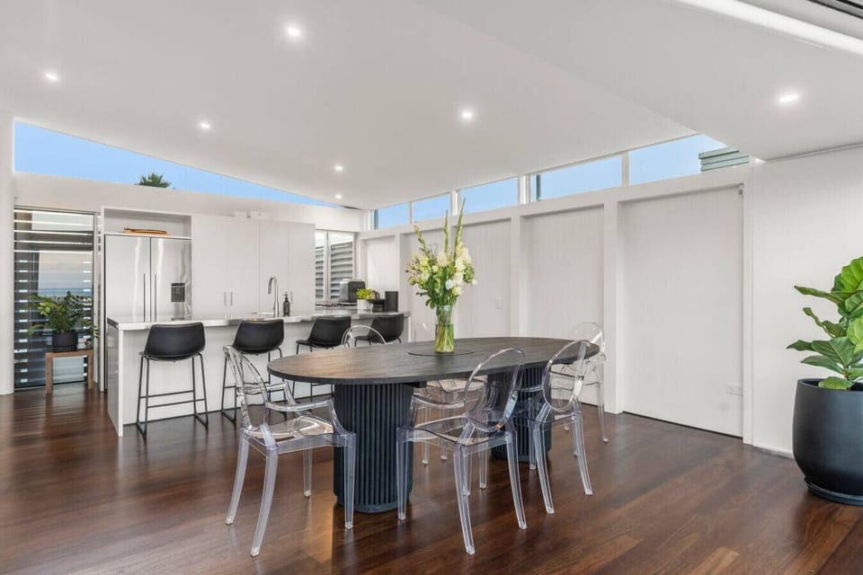 Spacious open plan living with fully equipped kitchen, bar seating and dining table and ocean views