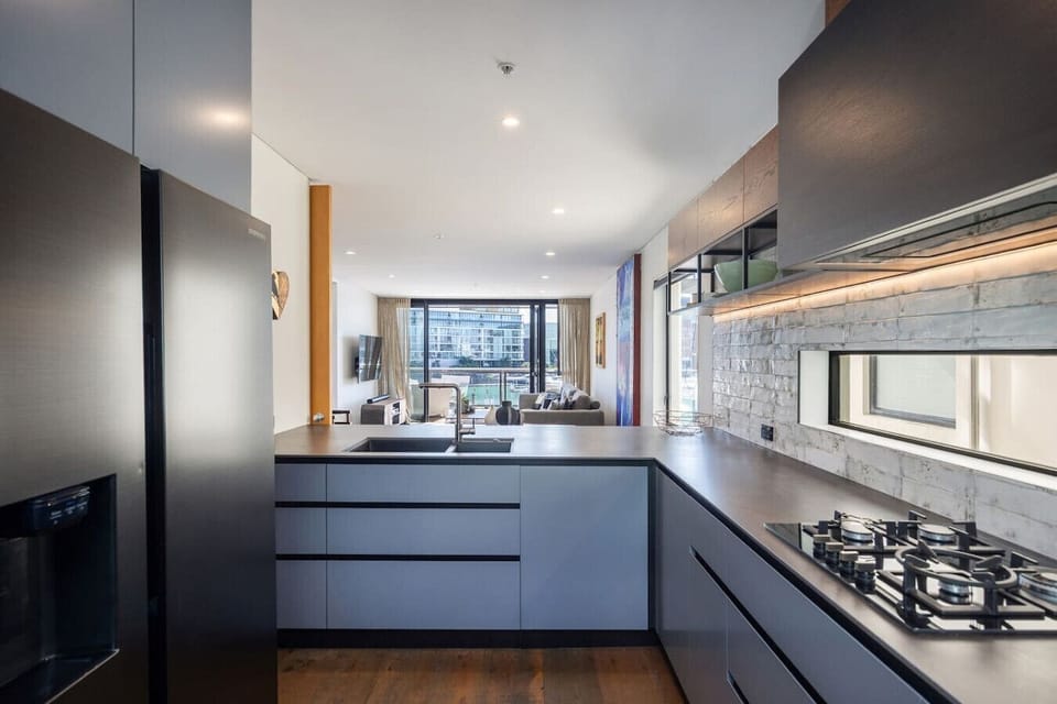 Fully equipped kitchen with bar seating, gas cooktop, oven, fridge freezer and dishwasher