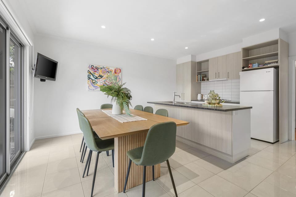 Bright kitchen-diner with island, seating for 6, and patio access.