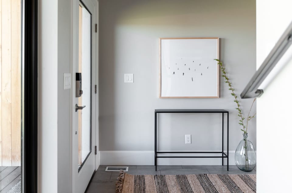 The welcoming entryway features a smart lock on the front door, a console table, and Teton-inspired art to set the tone.