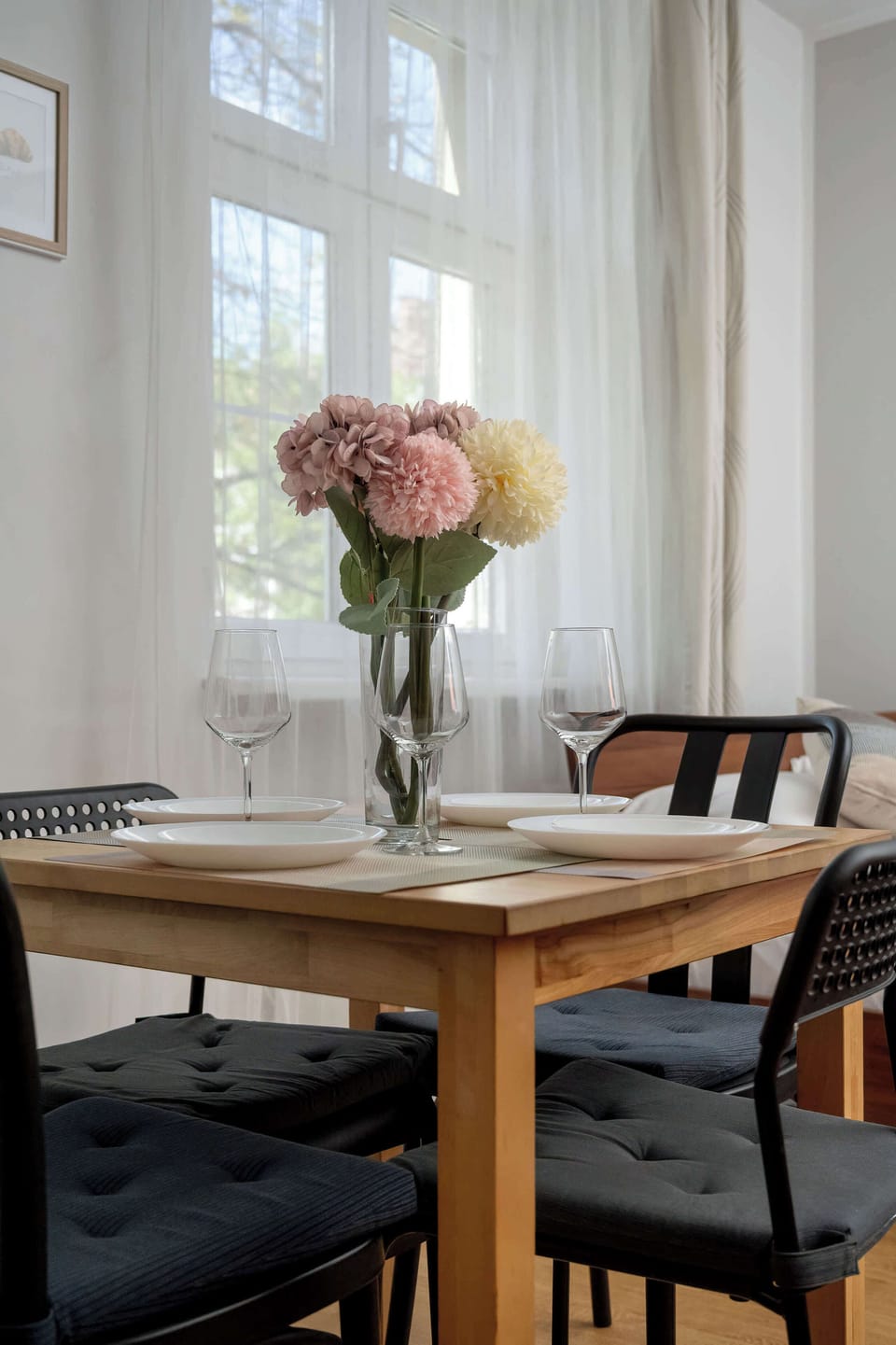 A close-up of a dining table with decorative flowers and neatly arranged settings. It creates a pleasant and welcoming dining atmosphere.