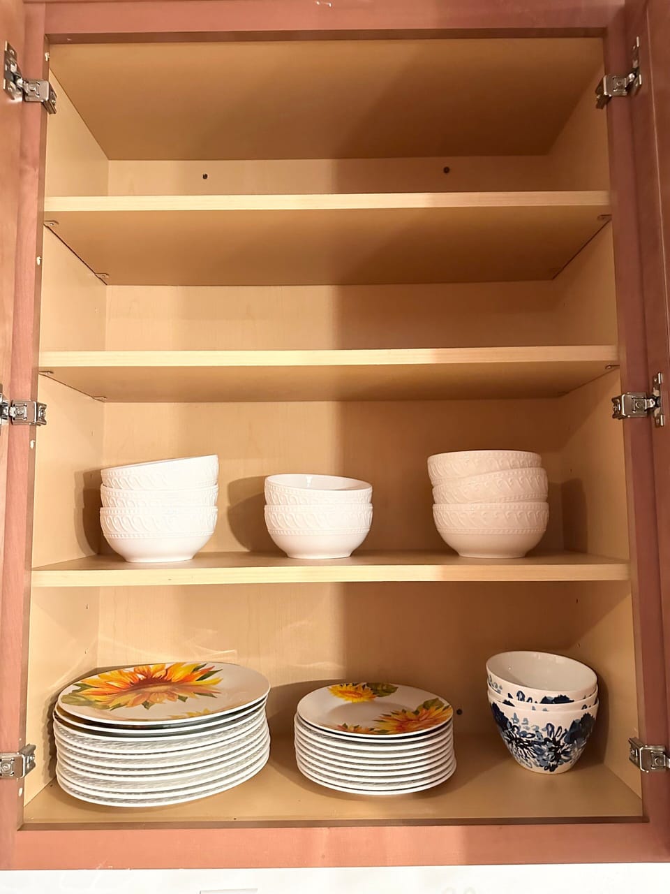 Open kitchen cabinet with bowls and plates.