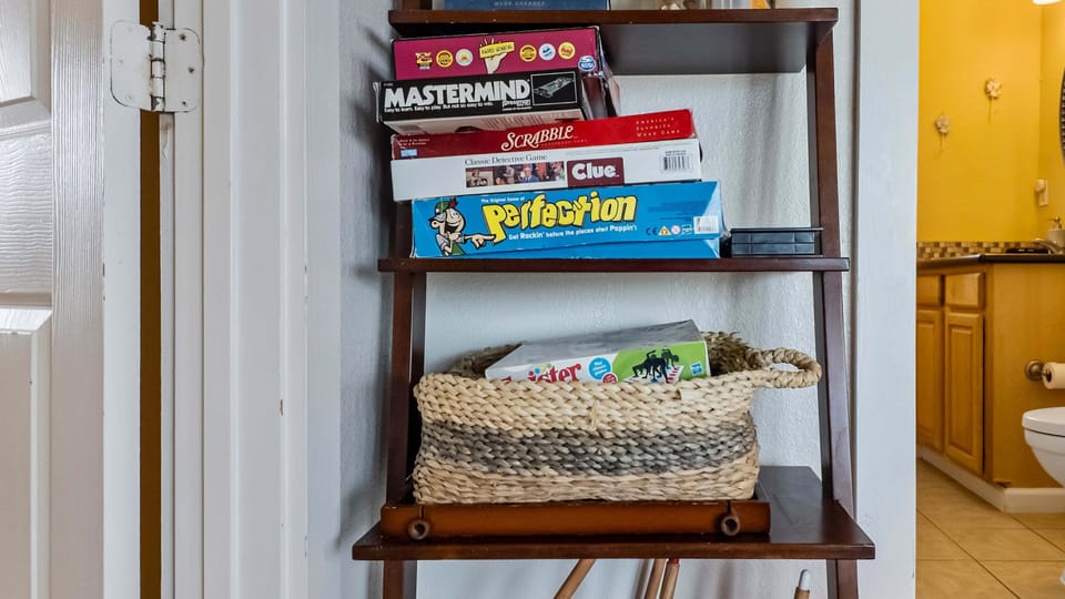 Family-friendly game and entertainment shelf stocked with board games and activities for fun-filled Galveston beach vacations.