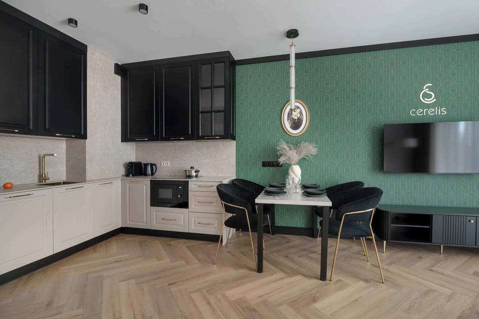 The kitchen layout is functional and sleek, featuring built-in appliances and a white tiled backsplash that reflects the light.